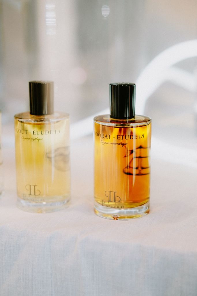 Glass perfume bottles with black lids against a light background