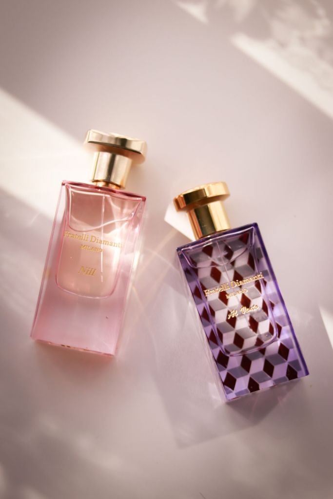Two glass perfume bottles photographed in soft light